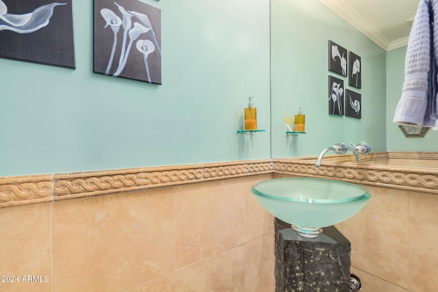 bathroom featuring tile walls, sink, and ornamental molding