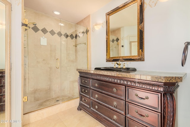 bathroom featuring vanity, a shower with shower door, and tile patterned flooring