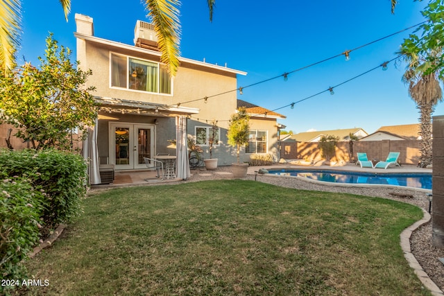 back of house with a fenced in pool, french doors, a patio, and a yard