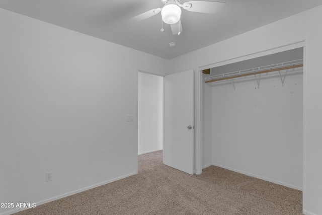 unfurnished bedroom with ceiling fan, light colored carpet, and a closet