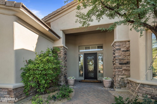 property entrance featuring stone siding and stucco siding