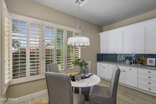 dining space featuring light wood finished floors and baseboards