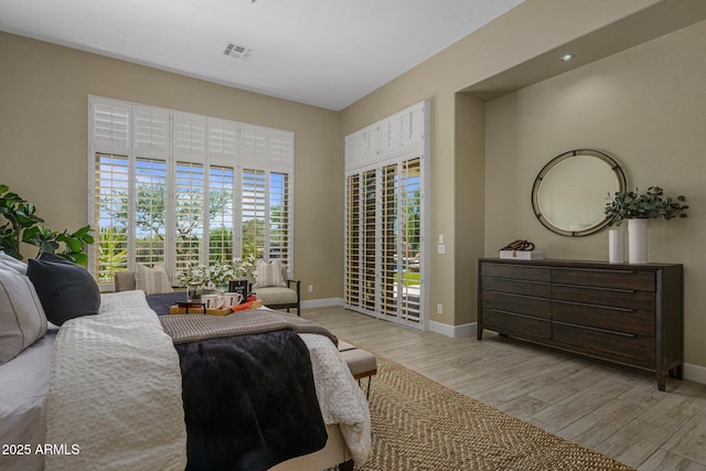 bedroom with access to exterior, baseboards, and wood finished floors