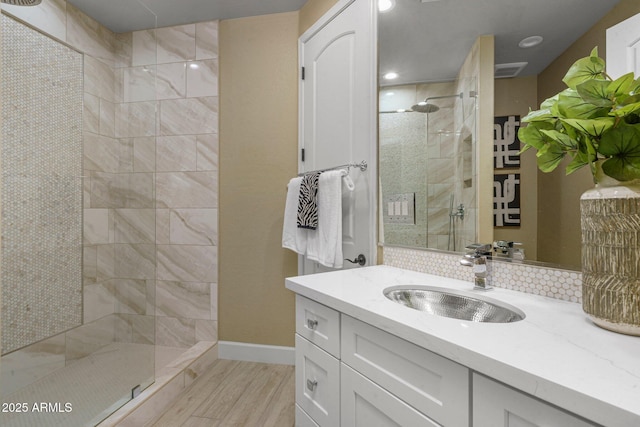 bathroom with walk in shower, baseboards, vanity, and recessed lighting