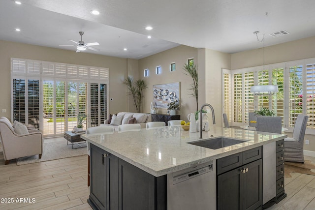 kitchen with a sink, dishwasher, open floor plan, an island with sink, and a ceiling fan