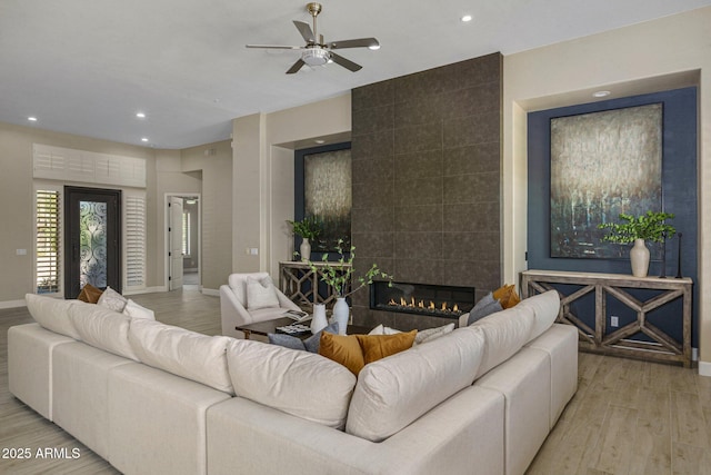 living room featuring wood finished floors, a ceiling fan, baseboards, and recessed lighting