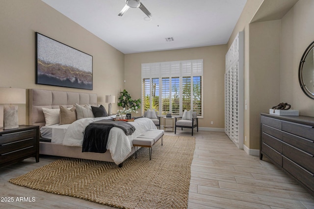 bedroom with light wood-type flooring, baseboards, and a ceiling fan