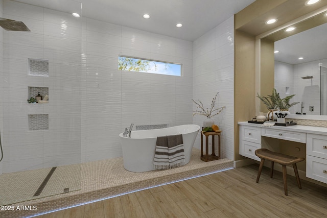 full bathroom with tiled shower, vanity, a freestanding bath, wood finished floors, and recessed lighting