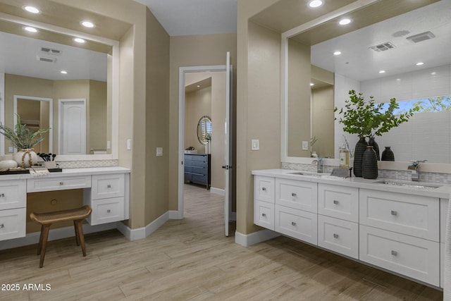 bathroom featuring wood finished floors, vanity, and baseboards