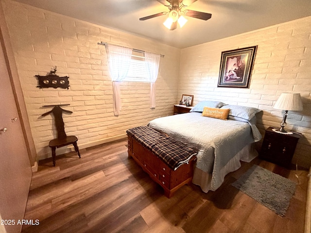 361 W Placer St, Ajo, AZ 85321 - bedroom featuring wood finished floors, brick wall, a ceiling fan, and baseboards