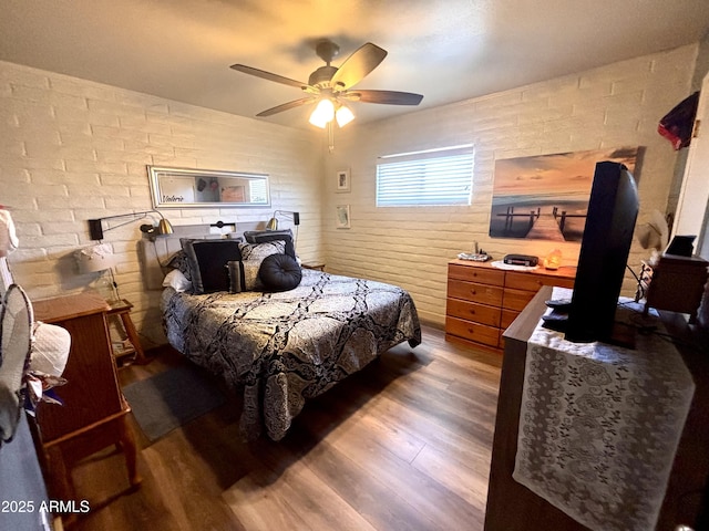 361 W Placer St, Ajo, AZ 85321 - bedroom featuring wood finished floors, a wood stove, brick wall, and a ceiling fan