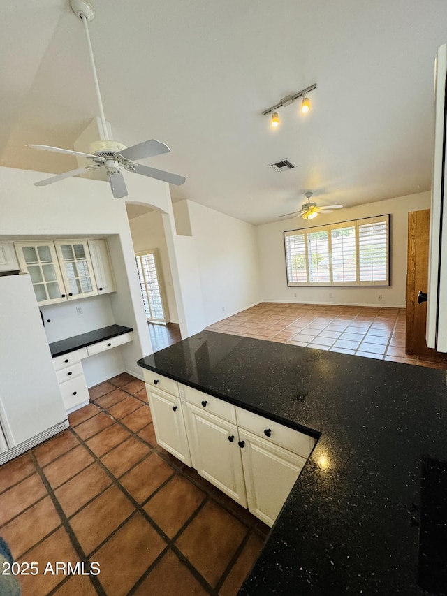 kitchen with rail lighting, built in desk, vaulted ceiling, dark tile patterned floors, and ceiling fan