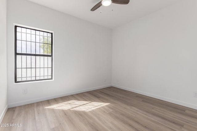 unfurnished room with a ceiling fan, light wood-style floors, and baseboards