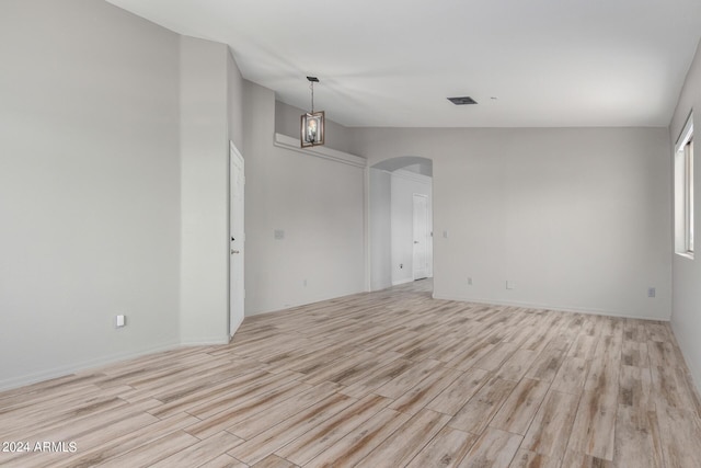 unfurnished room featuring light hardwood / wood-style floors and an inviting chandelier