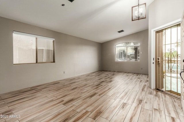 unfurnished room with light wood-type flooring and a chandelier