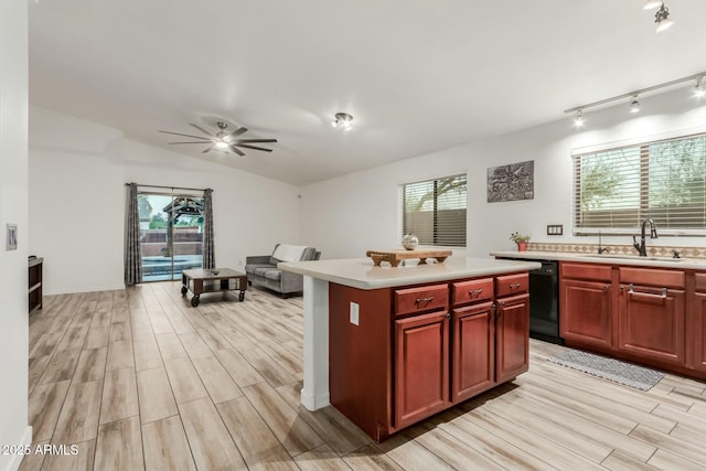 kitchen featuring dishwasher, a center island, sink, light hardwood / wood-style flooring, and ceiling fan