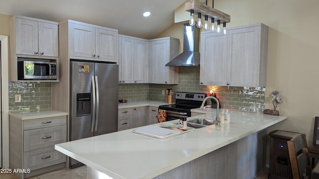 kitchen featuring tasteful backsplash, a peninsula, stainless steel appliances, light countertops, and wall chimney range hood