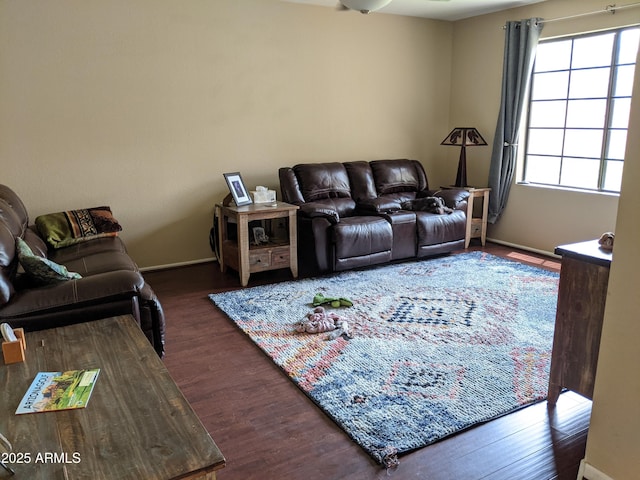 living area with baseboards and wood finished floors