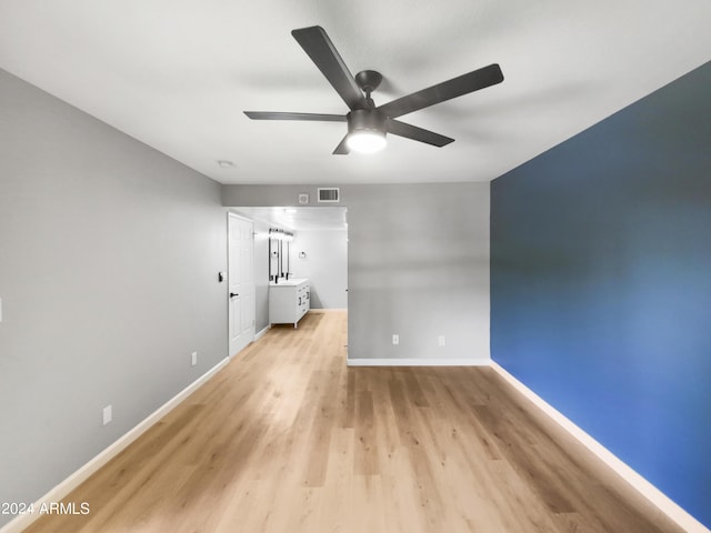 unfurnished room featuring ceiling fan, light wood-style floors, visible vents, and baseboards