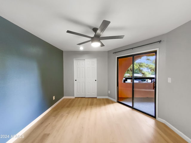 unfurnished bedroom featuring ceiling fan, access to outside, light wood-style flooring, and baseboards