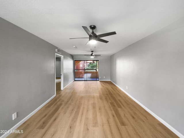 unfurnished room with light wood-type flooring, visible vents, baseboards, and ceiling fan