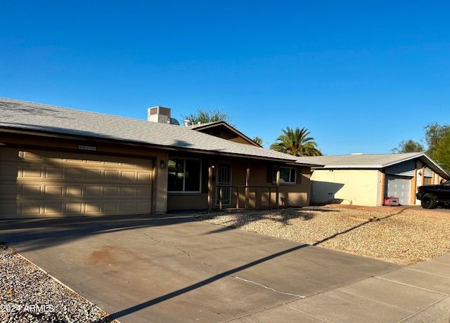 ranch-style house featuring central AC unit and a garage