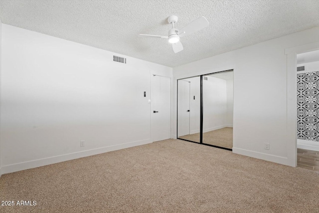 unfurnished bedroom featuring light carpet, a textured ceiling, ceiling fan, and a closet