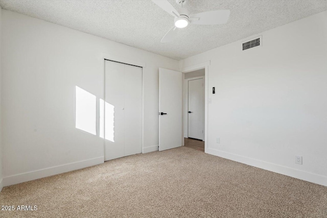 carpeted spare room featuring ceiling fan and a textured ceiling