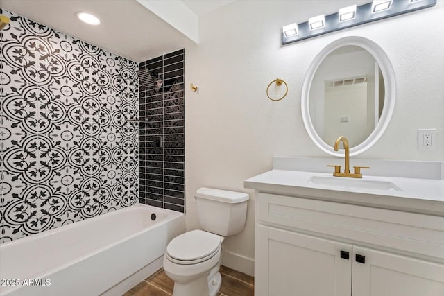 full bathroom featuring vanity, tiled shower / bath, hardwood / wood-style flooring, and toilet