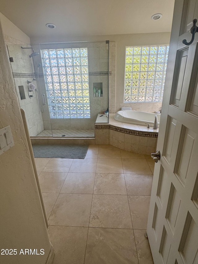 bathroom with tile patterned floors, a shower stall, and a bath