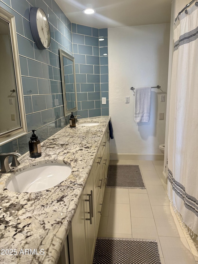 bathroom featuring toilet, tile patterned flooring, double vanity, and a sink