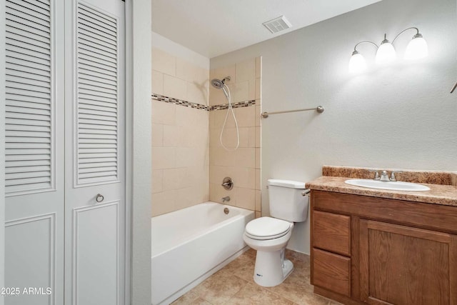 full bathroom featuring vanity, tiled shower / bath, tile patterned flooring, and toilet