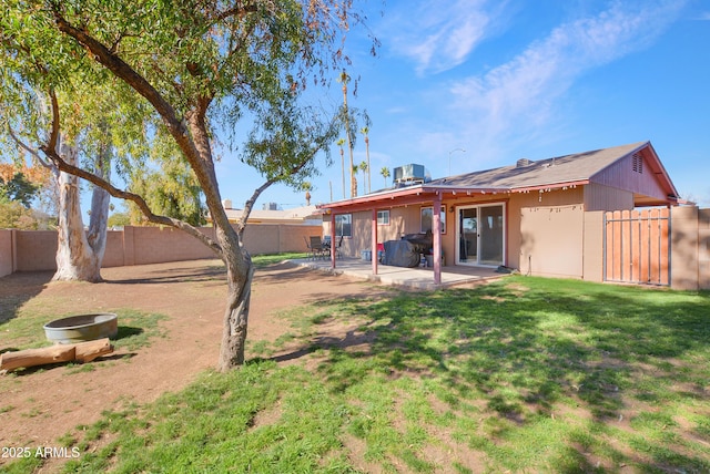 rear view of house with a patio and a lawn