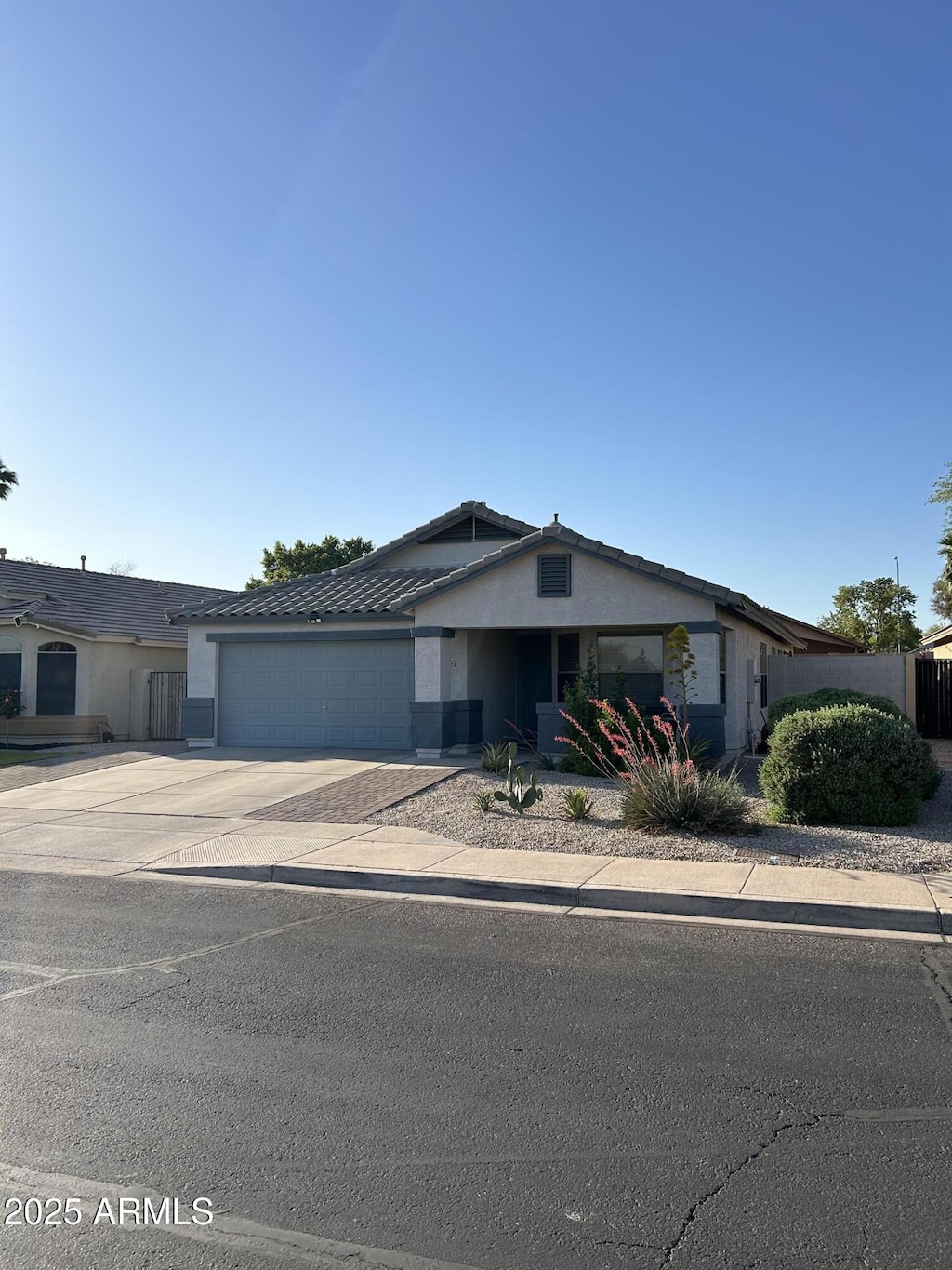 single story home with a garage, stucco siding, and concrete driveway