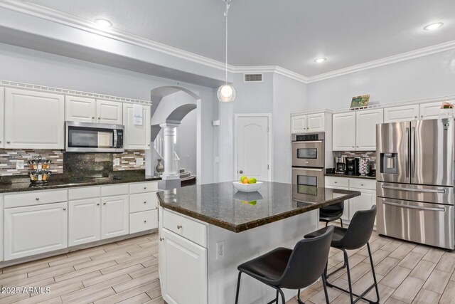 1442 W Laurel Ave, Gilbert, AZ 85233 - kitchen featuring appliances with stainless steel finishes, arched walkways, crown molding, white cabinetry, and tasteful backsplash