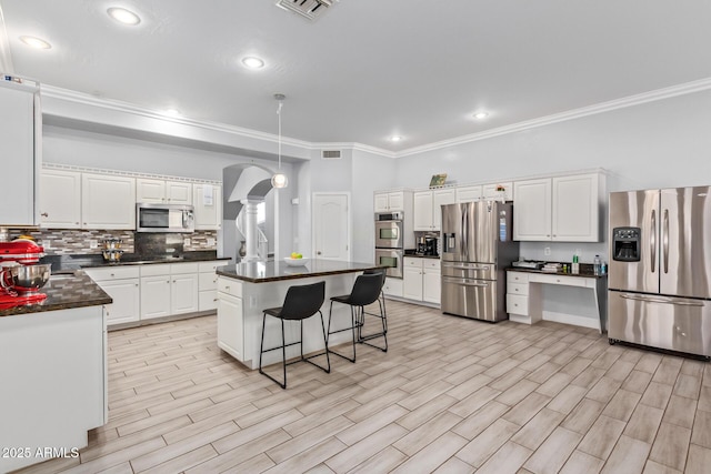 1442 W Laurel Ave, Gilbert, AZ 85233 - kitchen featuring appliances with stainless steel finishes, ornamental molding, dark countertops, white cabinetry, and a center island