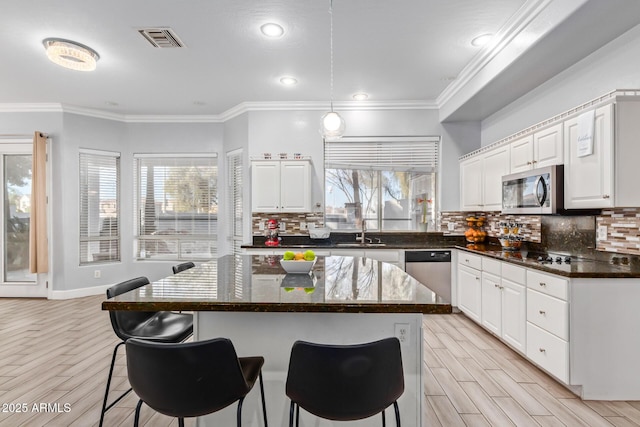 1442 W Laurel Ave, Gilbert, AZ 85233 - kitchen featuring appliances with stainless steel finishes, a sink, a kitchen bar, decorative backsplash, and ornamental molding