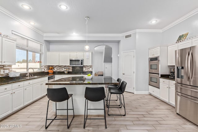 1442 W Laurel Ave, Gilbert, AZ 85233 - kitchen featuring appliances with stainless steel finishes, white cabinets, arched walkways, a sink, and tasteful backsplash