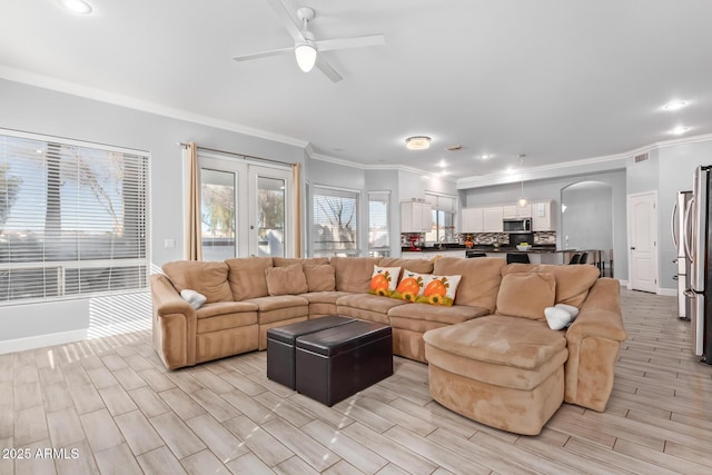 1442 W Laurel Ave, Gilbert, AZ 85233 - living area featuring ornamental molding, arched walkways, a ceiling fan, light wood-type flooring, and baseboards