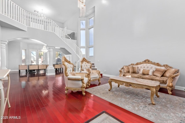 1442 W Laurel Ave, Gilbert, AZ 85233 - living room with decorative columns, arched walkways, wood finished floors, a towering ceiling, and baseboards