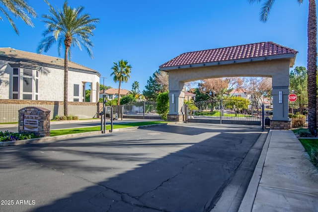 1442 W Laurel Ave, Gilbert, AZ 85233 - view of asphalt street with a gate, curbs, sidewalks, and traffic signs