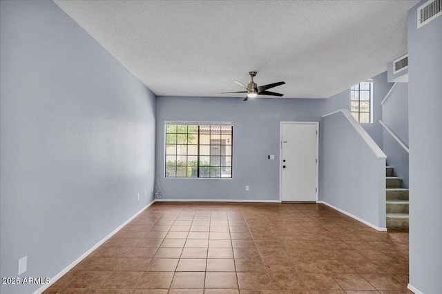 2954 N Oregon St Unit 6, Chandler, AZ 85225 - unfurnished room featuring healthy amount of natural light, a textured ceiling, ceiling fan, stairs, and tile patterned floors