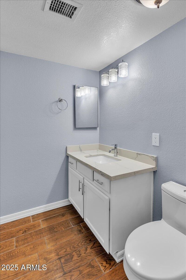 2954 N Oregon St Unit 6, Chandler, AZ 85225 - half bathroom with vanity, a textured wall, wood finished floors, and a textured ceiling