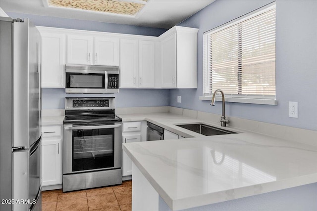 2954 N Oregon St Unit 6, Chandler, AZ 85225 - kitchen with stainless steel appliances, white cabinetry, light stone counters, light tile patterned flooring, and a peninsula