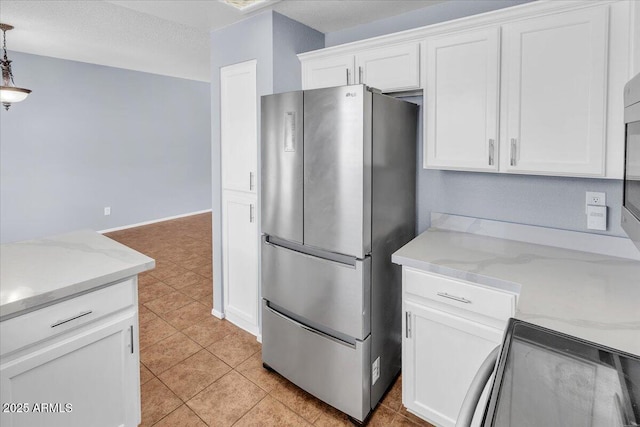 2954 N Oregon St Unit 6, Chandler, AZ 85225 - kitchen featuring freestanding refrigerator, white cabinetry, hanging light fixtures, light tile patterned floors, and light stone countertops