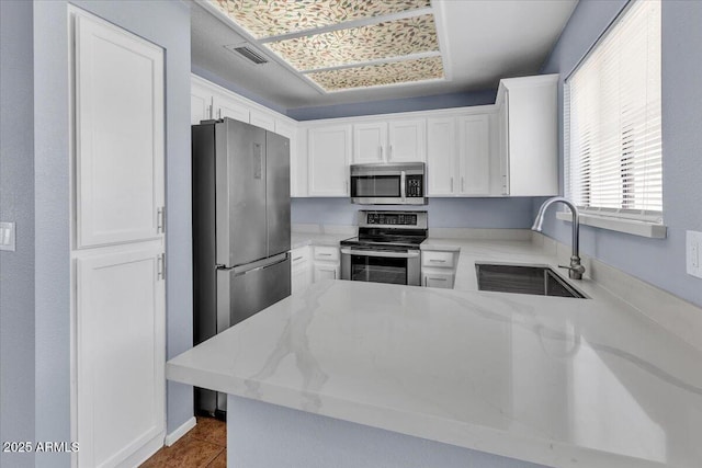 2954 N Oregon St Unit 6, Chandler, AZ 85225 - kitchen with stainless steel appliances, white cabinetry, light stone countertops, a peninsula, and dark tile patterned floors