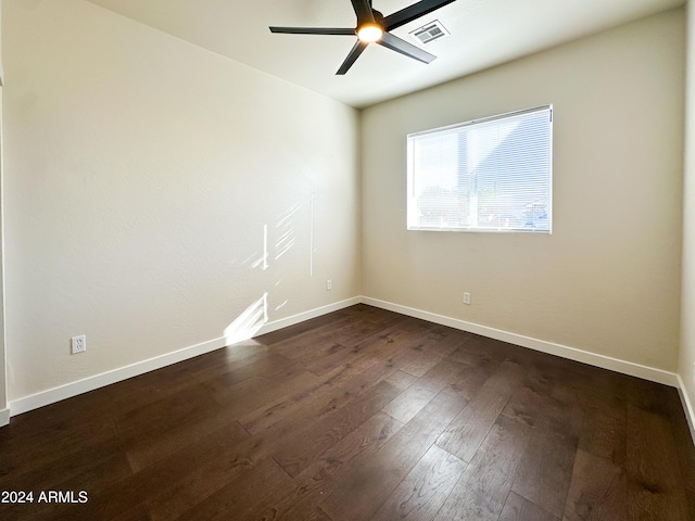 empty room with visible vents, baseboards, ceiling fan, and dark wood-style flooring