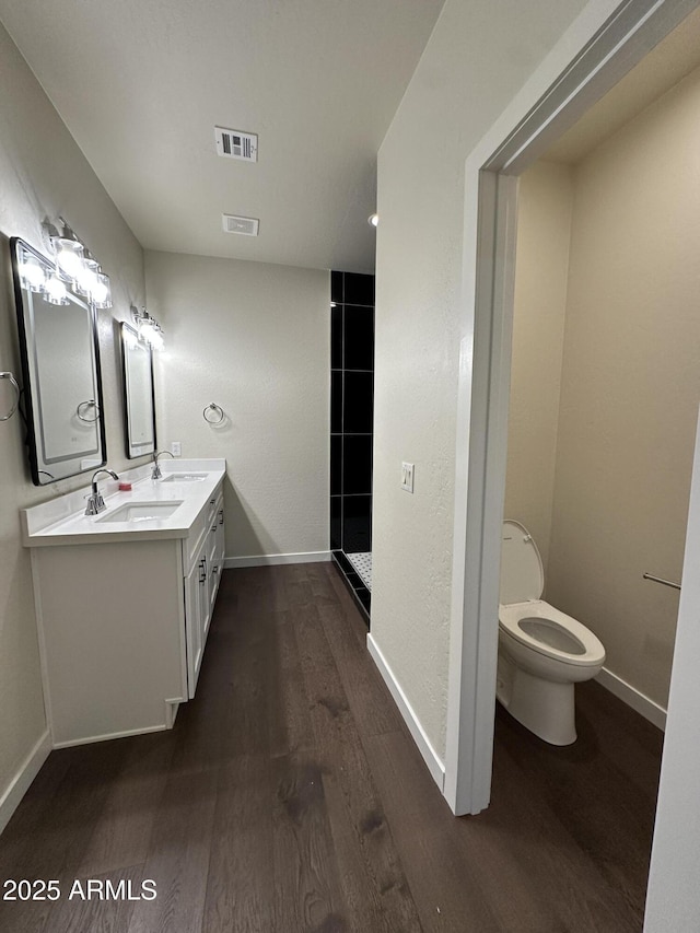 bathroom with visible vents, a sink, baseboards, and wood finished floors