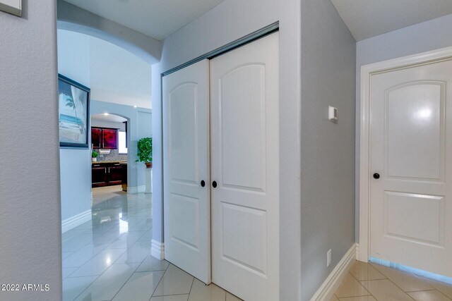 tiled bedroom with ceiling fan and a closet