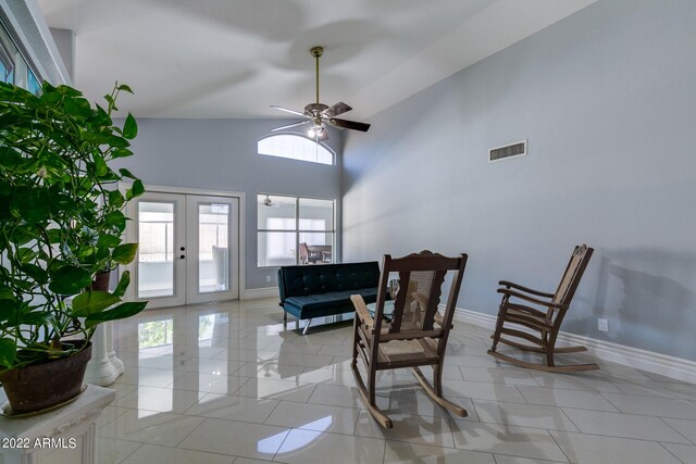 living area with ceiling fan, lofted ceiling, and light tile patterned floors